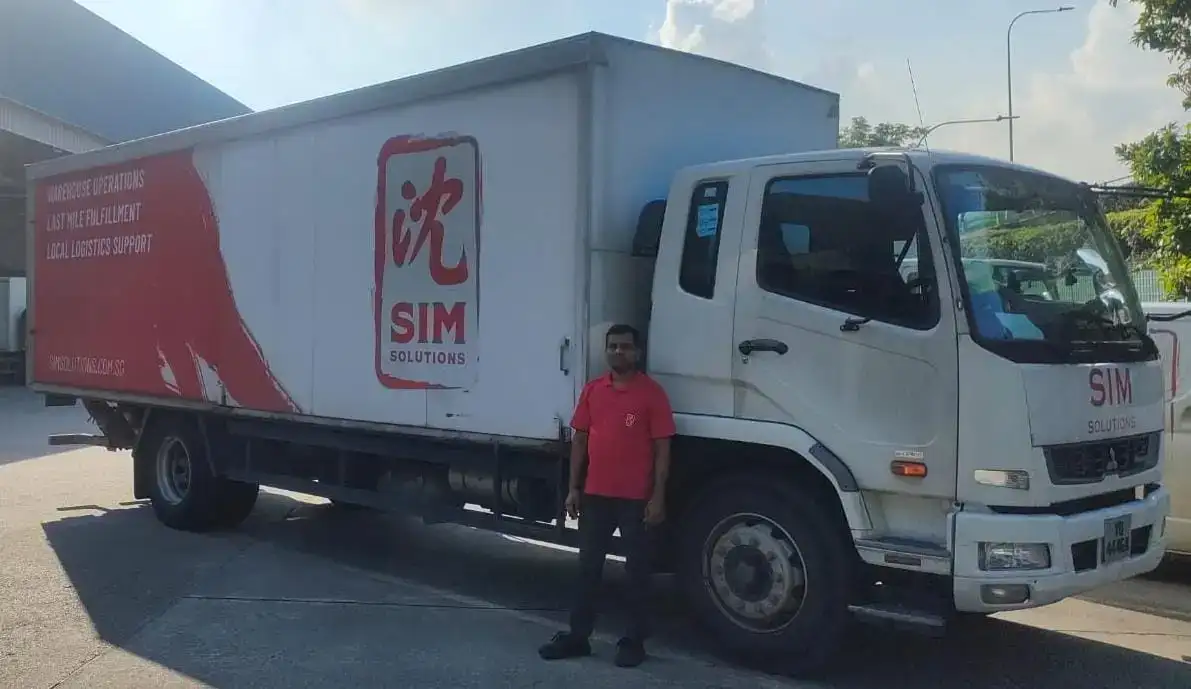 staff member in front of transportation lorry